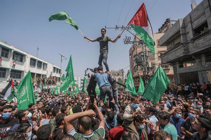 30 April 2021, Palestinian Territories, Jabalia: Supporters of the Palestinian Hamas Islamist movement wave flags during a demonstration against the postponement of Palestinian elections, which were supposed to be held on May 22nd. Palestinian President