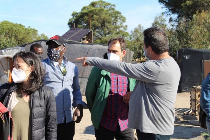 El eurodiputado de Unidas Podemos, Manu Pineda, el coordinador general de Izquierda Unida Andalucía, Toni Valero, y la diputada de Unidas Podemos en el Congreso, Isabel Franco, en un asentamiento de Palos de la Fra (Huelva).