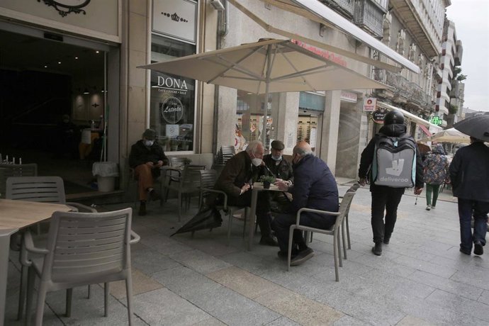 Varias personas en una terraza, el día en que entran en vigor nuevas medidas en la hostelería, en Vigo, Pontevedra, Galicia, (España). La Xunta ha decretado desde este viernes a las 00.00 el paso de la ciudad de Vigo a nivel medio debido a la crisis del