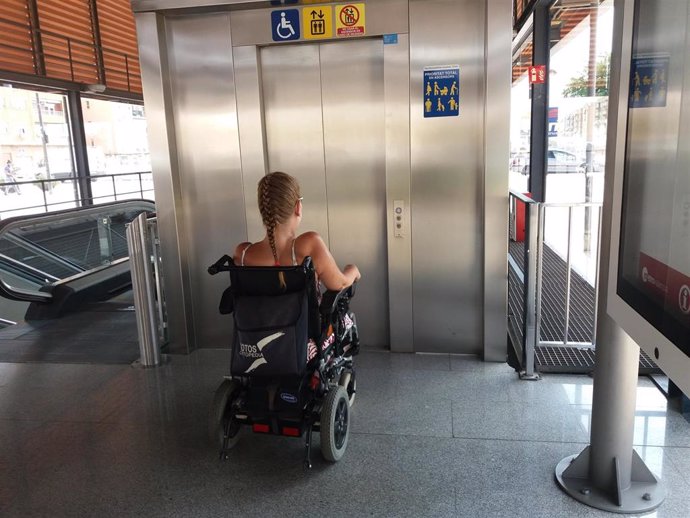 Archivo - Una mujer en silla de ruedas preparada para usar un ascensor