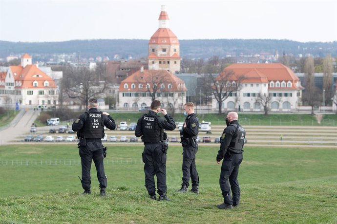 11 April 2021, Saxony, Dresden: Police officers secure the access road to a parking lot in front of the trade fair grounds, host venue of the Alternative for Germany (AfD) federal party conference. Photo: Sebastian Kahnert/dpa-Zentralbild/dpa