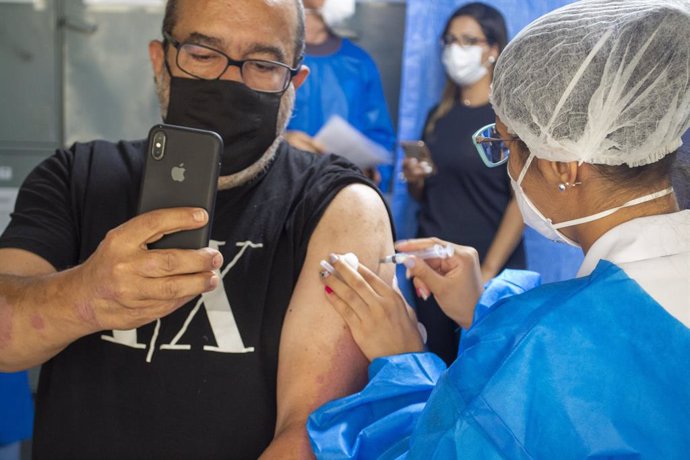 05 April 2021, Brazil, Sao Paulo: A police officer takes a selfie while being vaccinated against COVID-19 during a campaign to vaccinate police officers in Sao Paulo. Photo: Leco Viana/TheNEWS2 via ZUMA Wire/dpa