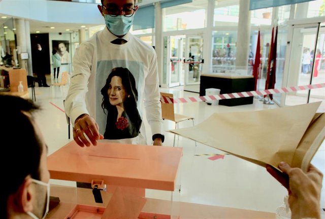 Un hombre acude a votar con una camiseta de Isabel Díaz Ayuso en el Centro cultural Alfredo Krauss.