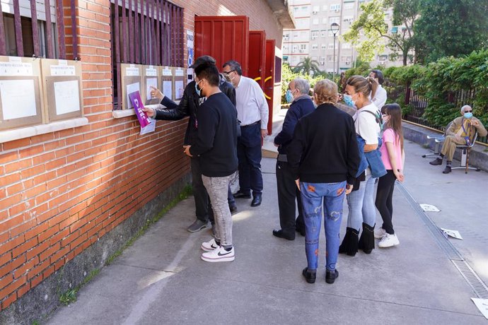 Votants esperen una cua a les portes del Collegi Rosalía de Castro, a 4 de maig de 2021, a Móstoles, Madrid (Espanya). 