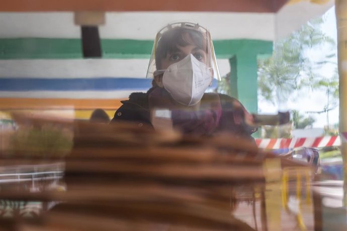 Una mujer en una mesa electoral a la hora de comer en el Colegio Público Asturias en el distrito Puente de Vallecas, a 4 de mayo de 2021, en Madrid (España). 