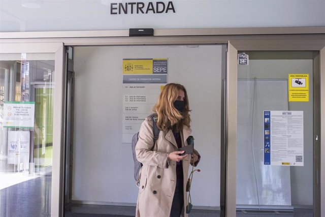 Una mujer entra por la puerta de una oficina del SEPE.