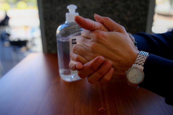 Archivo - Una persona se desinfecta las manos con gel hidroalcohólico, foto de recurso