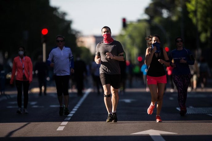 Archivo - Varias personas hacen deporte protegidas con mascarillas 