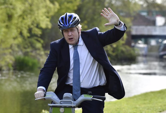 05 May 2021, United Kingdom, Stourbridge: UK Prime Minister Boris Johnson waves as he rides a bike along the towpath of the Stourbridge canal during the local election campaign trail. Photo: Rui Vieira/PA Wire/dpa
