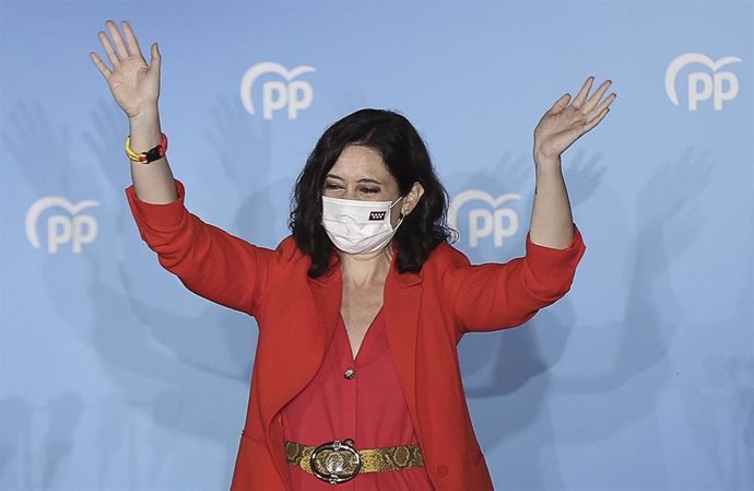 La presidenta de la Comunidad de Madrid y candidata a la reelección por el PP, Isabel Díaz Ayuso, saluda desde el balcón de la sede del partido para celebrar los primeros sondeos durante la jornada electoral, a 4 de mayo de 2021, en la Sede del Partido 