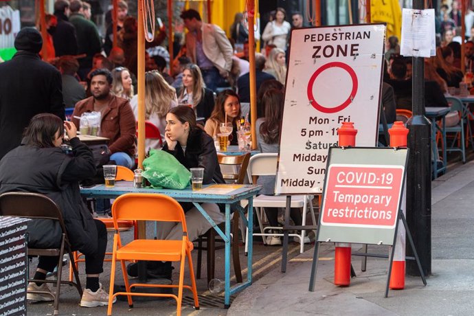 24 April 2021, United Kingdom, London: People are seen at an outdoor restaurant in Soho square following the further easing of lockdown restrictions in England. Photo: Dominic Lipinski/PA Wire/dpa