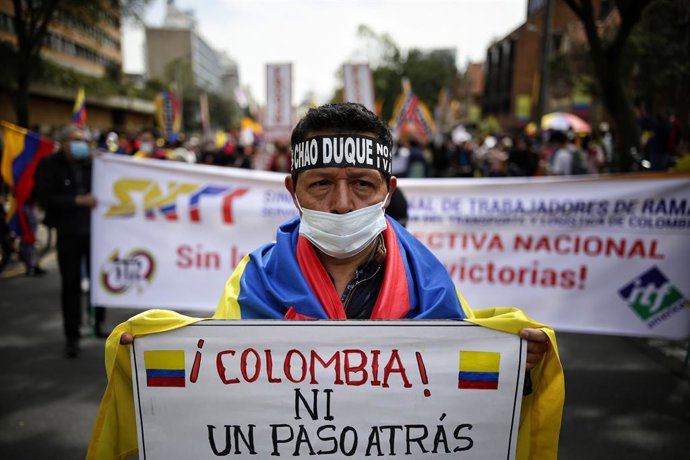 05 May 2021, Colombia, Bogota: A demonstrator holds a placard reading "Colombia - don't take a step back,"  during a protest against President Duque's government and police violence following the death of at least 19 people during last week rallies. Pho