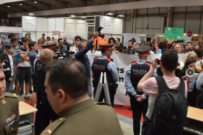 Archivo - Protesta de la plataforma Desmilitaritzem l'Educació en la feria de educación de Lleida en 2018. Foto de archivo.