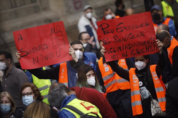 Participantes llevan carteles contra el ERE en H&M en una concentración convocada en Barcelona