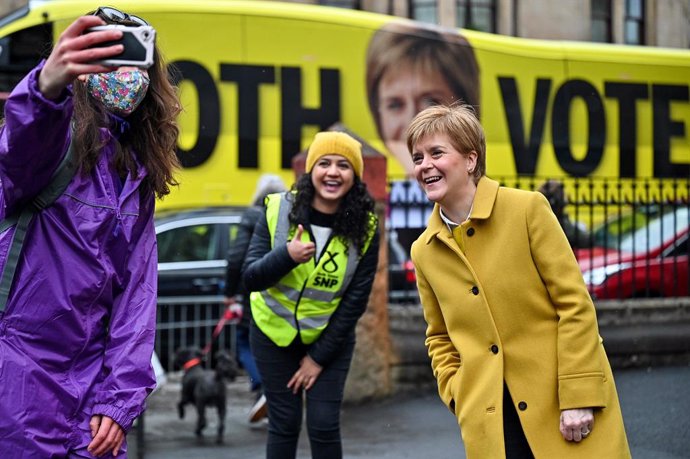 06 May 2021, United Kingdom, Glasgow: First Minister and leader of the Scottish National Party (SNP) Nicola Sturgeon (R) poses for a selfie with supporters as she arrives to cast her vote at a polling station during the Scottish Parliamentary election. 