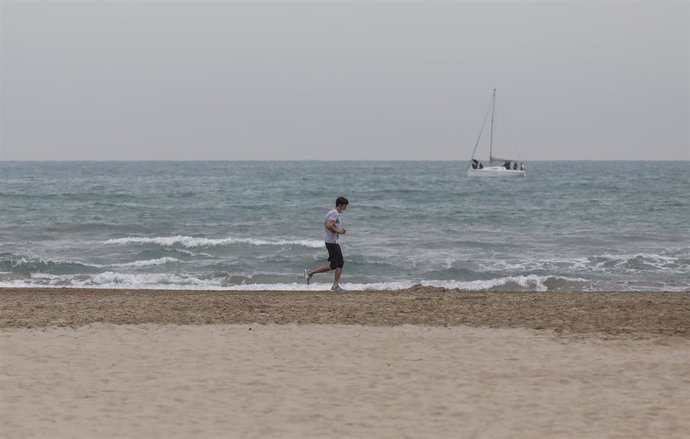 Archivo - Un hombre hace deporte con mascarilla en la playa la Malvarrosa en Valncia. 