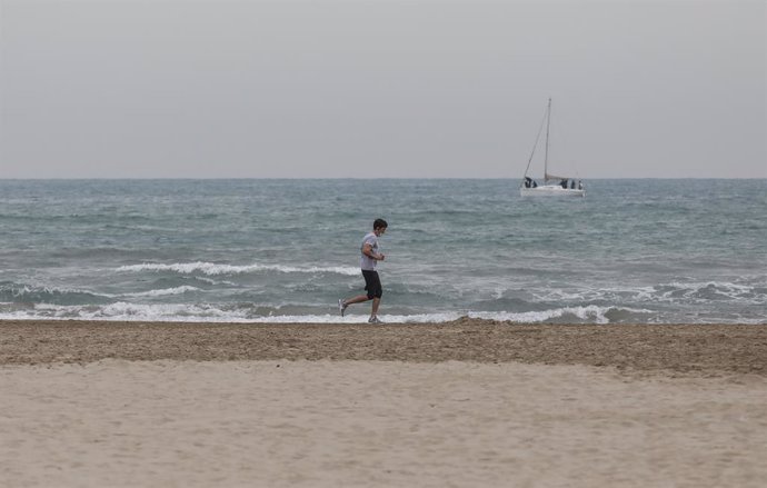 Archivo - Arxiu - Un home fa esport amb mascareta en la platja la Malvarrosa a Valncia. 