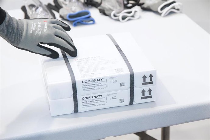 Un trabajador saca de una caja el envío de vacunas de Pfizer/BioNTech contra el Covid-19