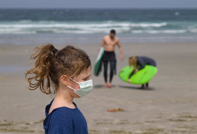 Una niña lleva una mascarilla en la Playa das Salseiras, en La Coruña (Galicia).