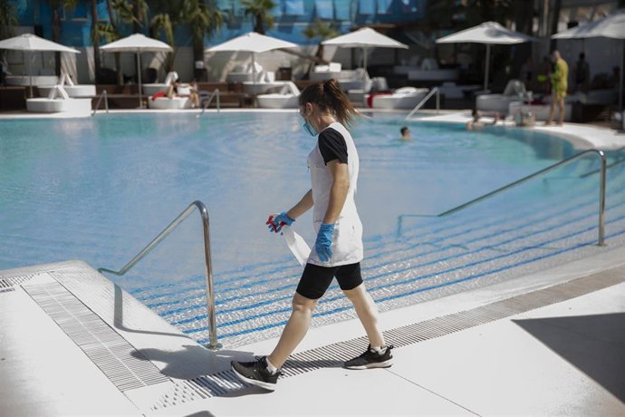 Archivo - Una trabajadora realiza tareas de desinfección en una piscina. 