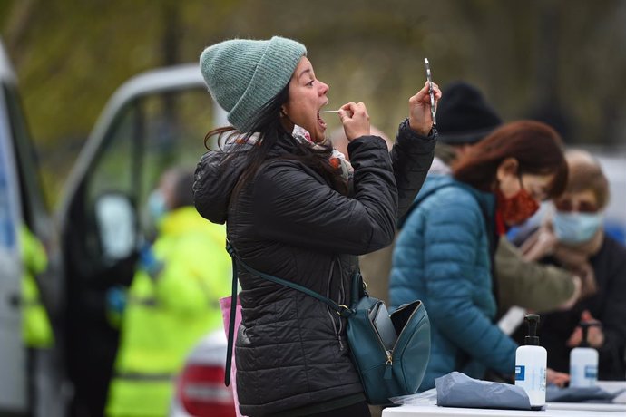 13 April 2021, United Kingdom, London: A lgirl takes a nasal swab herself during a coronavirus surge testing on Clapham Common. Thousands of residents have queued up to take coronavirus tests at additional facilities set up after new cases of the South 