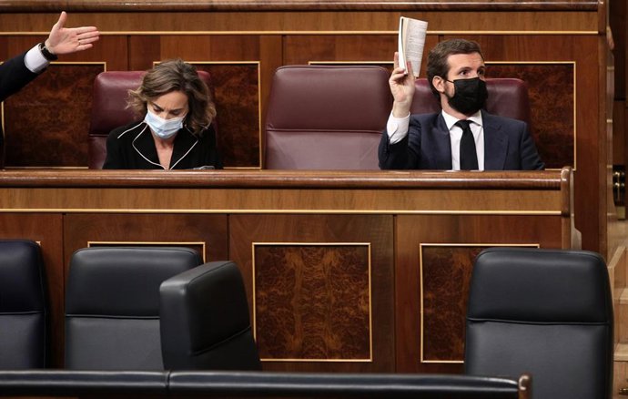 Archivo - El líder del PP, Pablo Casado, muestra la Constitución Española durante su intervención en una nueva sesión de control al Gobierno
