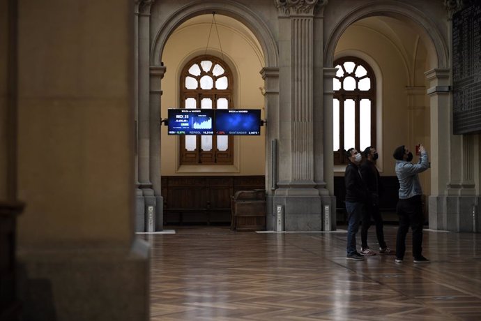 Un grupo de personas realiza una fotografía a los valores del Ibex 35 en el Palacio de la Bolsa, a 19 de abril de 2021, en Madrid, (España). Este lunes está marcado por una subida del Ibex del 0,2%, lo que ha llevado al selectivo a situarse en los 8.630