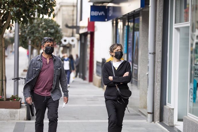 Archivo - Un hombre y una mujer caminan por una calle de O Grove, el día en que entra en vigor el cierre perimetral del municipio, a 8 de abril de 2021, en O Grove, Pontevedra, Galicia, (España).  