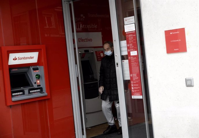 Archivo - Un hombre saca dinero de un cajero del Banco Santander.