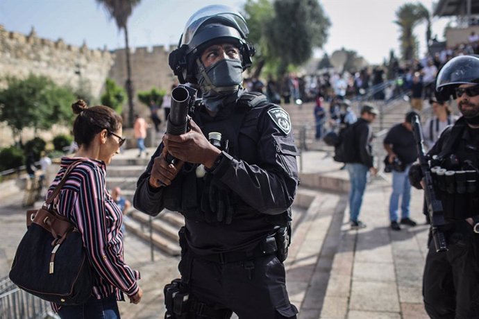 10 May 2021, Israel, Jerusalem: An Israeli police officer aims his weapon at the Damascus gate, ahead of march marking Israel's 1967 takeover of the holy city of Jerusalem. Photo: Ilia Yefimovich/dpa