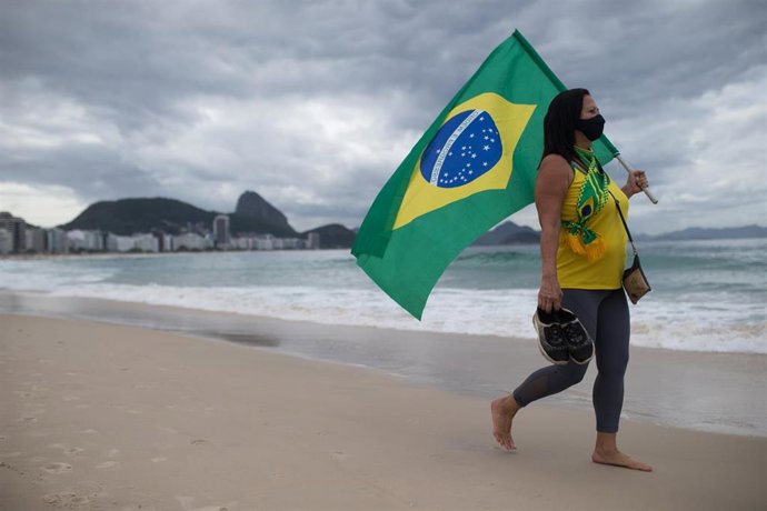 Partidarios del presidente brasileño Jair Bolsonaro sostiene una bandera durante una protesta en la playa de Copacabana.