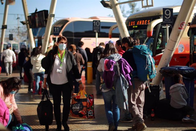 Archivo - Personas con mascarillas en una estación de autobuses en Santiago, Chile