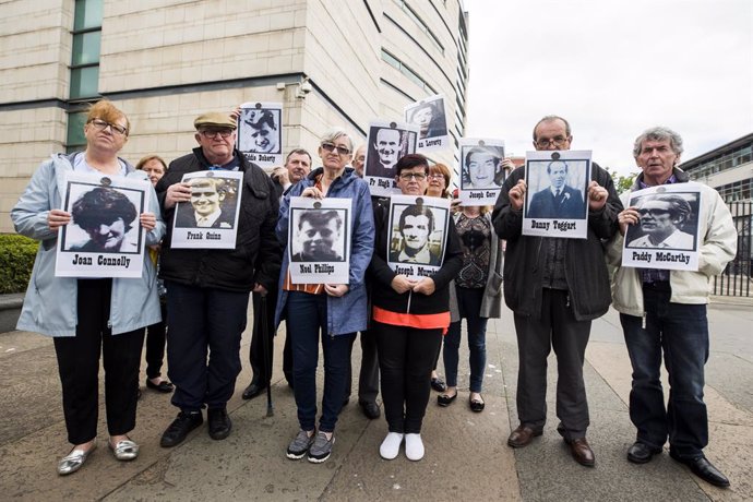 Archivo - 11 June 2019, Northern Ireland, Belfast: People hold images of their relatives who died in the Ballymurphy Massacre outside Laganside Court as the inquest continues into the series of incidents between 9 and 11 August 1971, in which the 1st Ba
