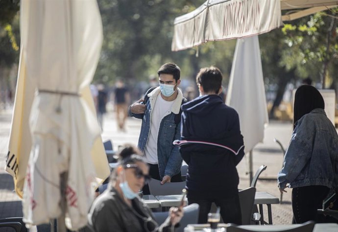 Archivo - Varias personas con mascarilla en la terraza de un bar