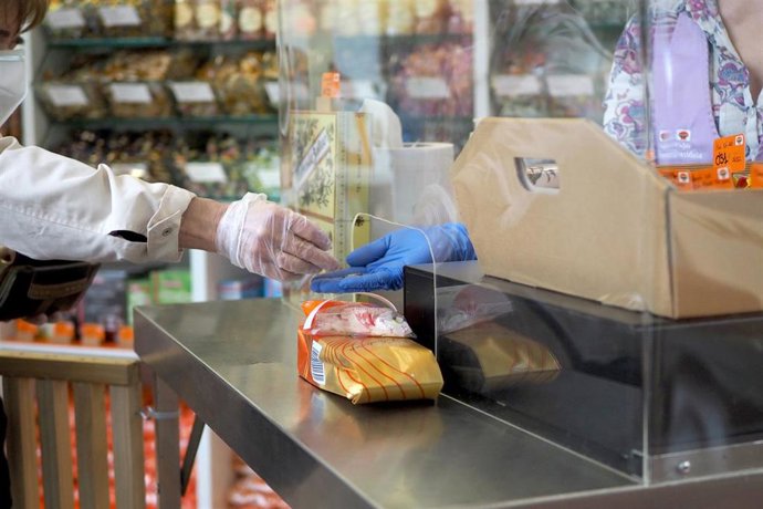 Archivo - Una persona es atendida por una trabajadora de una farmacia de Vitoria