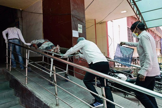 07 May 2021, India, Prayagraj: Family members transport a man suffering from coronavirus complications to the Swaroop Rani Nehru Hospital. Photo: Prabhat Kumar Verma/ZUMA Wire/dpa