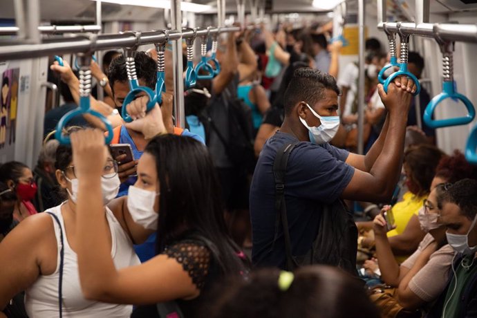 Archivo - 01 April 2021, Brazil, Rio de Janeiro: Passengers stand close together in a subway train. Rio De Janeiro is currently under tightened measures against the spread of the coronavirus (Covid-19). A total of 321,515 people have died in Brazil in c