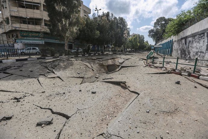 12 May 2021, Palestinian Territories, Gaza City: A view of huge pothole in the middle of a street in Gaza City after Israeli air strikes overnight amid the escalating flare-up of Israeli-Palestinian violence. Photo: Mohammed Talatene/dpa