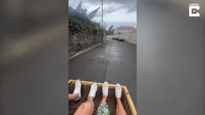 Turistas bajan en cestas de mimbre por las empinadas calles de Madeira