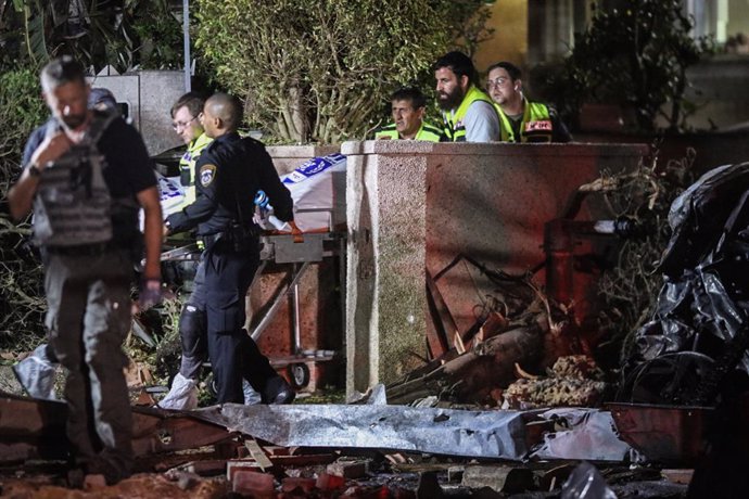 11 May 2021, Israel, Berlin: Israeli security and emergency personnel work at a site hit by rockets fired by the Palestinian Islamist movement Hamas from Gaza towards Israel, in the Israeli city of Rishon Lezion, south of Tel Aviv. Hundreds of rockets a