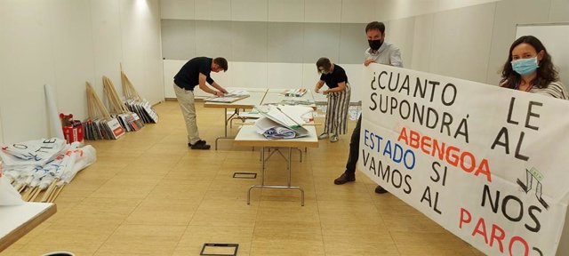 Un grupo de trabajadores de Abengoa realizan pancartas reivindicativas para la concentración de este jueves.