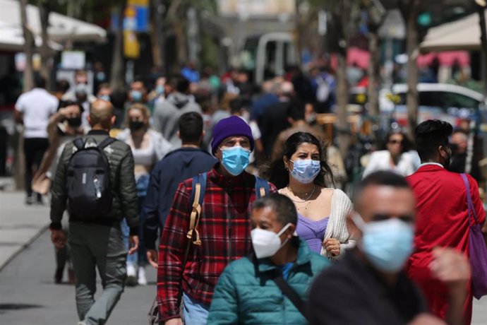 Varias personas caminan en Gran Vía durante el primer día laboral tras el estado de alarma, a 10 de mayo de 2021, en Madrid (España). 