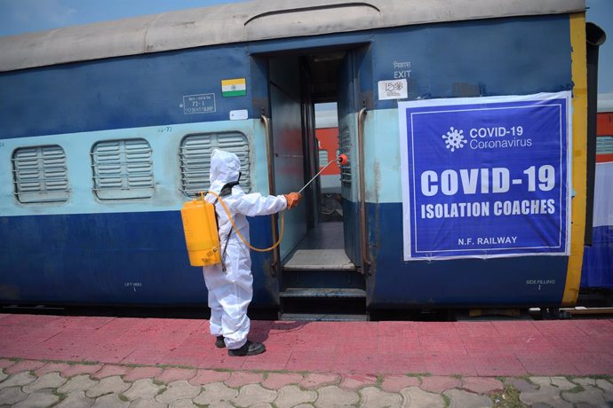 Un trabajador sanitario desinfecta un vagón de tren convertido en sala de aislamiento para pacientes de coronavirus en India