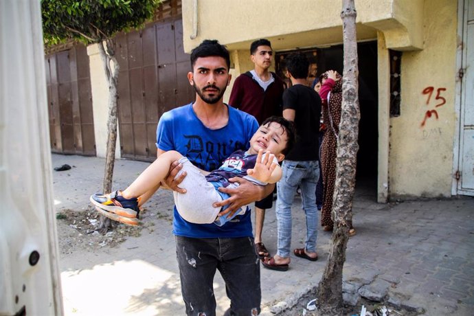 Un hombre lleva a un niño herido durante los ataques aéreos israelíes en Beit Lahia en medio de la escalada de violencia israelí-palestina. 