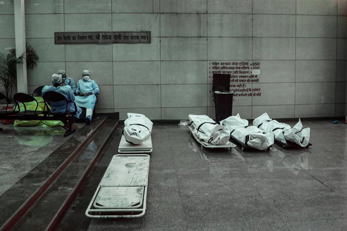 Imagen de archivo del personal sanitario junto a varios cuerpos en India.