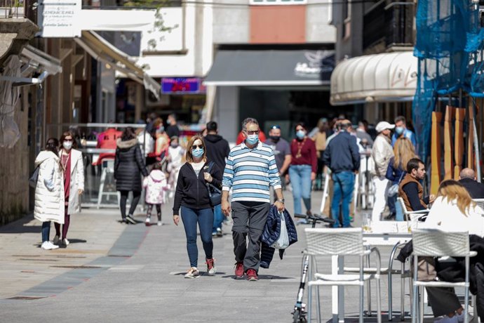 Archivo - Varias personas pasean por una céntrica calle de Sanxenxo.
