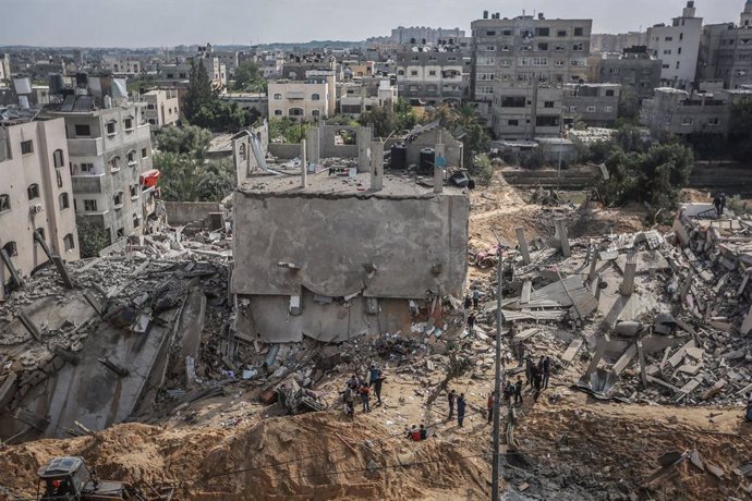 13 May 2021, Palestinian Territories, Beit Lahia: People inspect a destroyed building on the northern Gaza Strip town of Beit Lahia after it was hit by an Israeli airstrike early in the morning, amid the escalating flare-up of Israeli-Palestinian violen