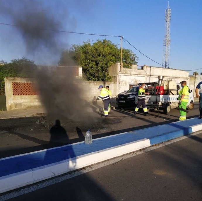 Operarios trabajan en la limpieza de las calles de La Línea tras los disturbios sucedidos de madrugada.