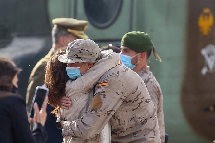 Un soldado se abraza a su mujer durante el acto de reconocimiento al personal participante en misiones en Afganistán, en la Base Aérea de Torrejón de Ardoz, a 13 de mayo de 2021, en Torrejón de Ardoz, Madrid (España). El Rey recibe hoy a las últimas tro