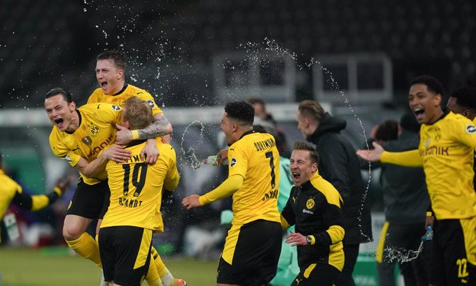 13 May 2021, Berlin: Dortmund players celebrate their victory after the final whistle of the German Cup (DFB Pokal) final soccer match between RB Leipzig and Borussia Dortmund at the Olympic Stadium. Photo: Michael Sohn/AP-Pool/dpa - IMPORTANT NOTICE: D